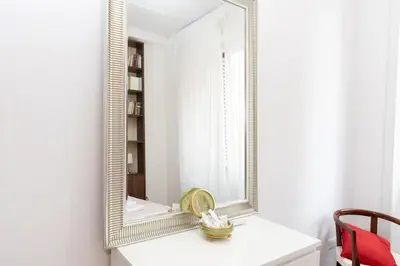 a mirror on a white wall in a room at 10 Min Città del Vaticano-Stadio olimpico Lucia Apartment 1BDR in Rome