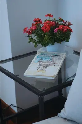 a glass table with a vase with flowers on it at 10 Min Città del Vaticano-Stadio olimpico Lucia Apartment 1BDR in Rome