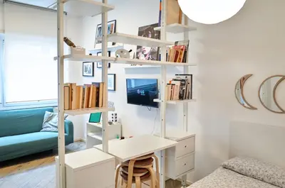 a room with a desk and a shelf with books at 10 Minuti Stazione Trastevere - Atelier 19 1BDR by Hôtea in Rome