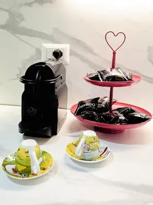 a coffee maker and plates of food on a table at 10 Minuti Stazione Trastevere - Atelier 19 1BDR by Hôtea in Rome