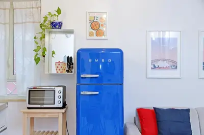 a blue refrigerator in a living room with a microwave at La corte di San Paolo by DomusDimore in Rome