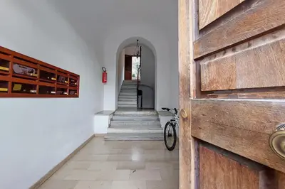 a hallway with a wooden door and stairs with a bike at La corte di San Paolo by DomusDimore in Rome