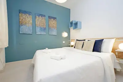 a large white bed in a room with blue walls at La corte di San Paolo by DomusDimore in Rome