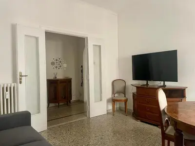 a living room with a tv on a wooden dresser at Antoni House San Giovanni in Rome