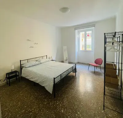 a bedroom with a bed and a chair and a window at Antoni House San Giovanni in Rome