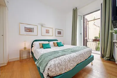 a bedroom with a bed and a large window at Balcony al Colosseo by Luxury Getaways in Rome