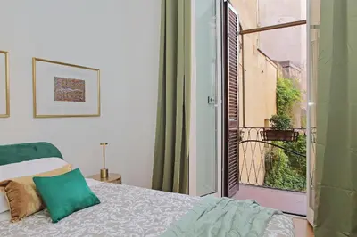 a bedroom with a bed and an open window at Balcony al Colosseo by Luxury Getaways in Rome