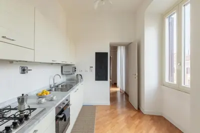 a white kitchen with a sink and a stove at HospitalityRome Doninzetti 20 in Rome
