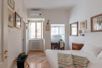 a bedroom with a white bed and a desk in it at iFlat Charming & Spacious Flat in Trastevere in Rome