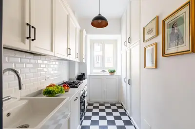 a kitchen with white cabinets and a checkered floor at iFlat Charming & Spacious Flat in Trastevere in Rome