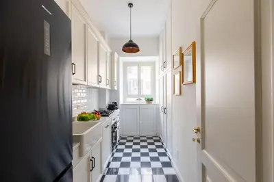 a kitchen with a black and white checkered floor at iFlat Charming & Spacious Flat in Trastevere in Rome