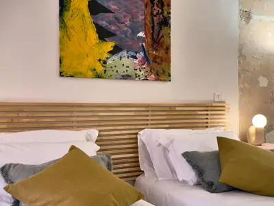 a bedroom with two beds and a painting on the wall at La Casa al Colosseo in Rome