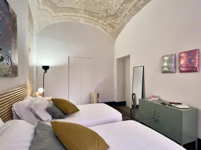 a bedroom with two beds and a ceiling at La Casa al Colosseo in Rome