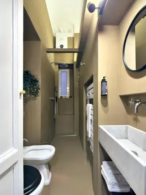 a bathroom with a toilet and a sink and a mirror at La Casa al Colosseo in Rome