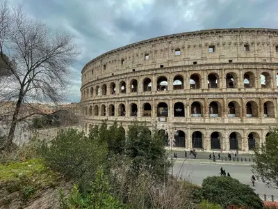 a large amphitheater with people walking around the coliseum at La Casa al Colosseo in Rome