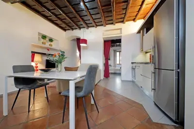 a kitchen and dining room with a white table and chairs at Trastevere Historic Loft by Luxury Getaways in Rome
