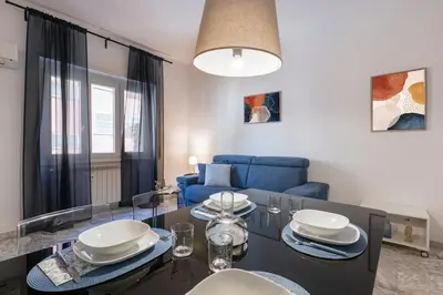 a living room with a table and a blue couch at Casa Laberio by Hili in Rome