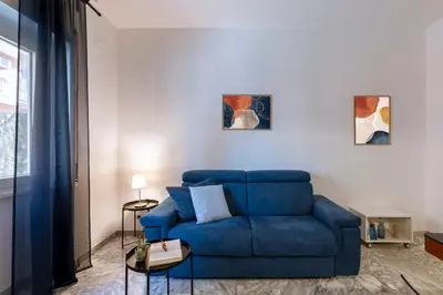 a blue couch in a living room with two paintings at Casa Laberio by Hili in Rome