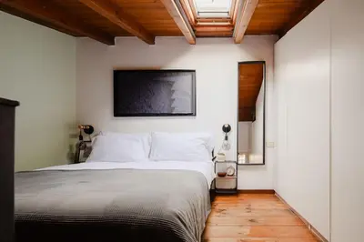 a bedroom with a bed and a tv on the wall at Casa Piccinino in Rome