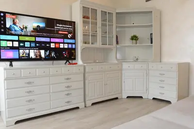 a room with white dressers and a flat screen tv at Locazione turistica di Carlo in Rome