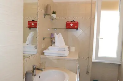 a bathroom with a sink and towels on a wall at Locazione turistica di Carlo in Rome