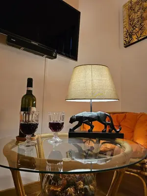 a glass table with a bottle of wine and a lamp at Private SPA Apartment in Rome in Rome