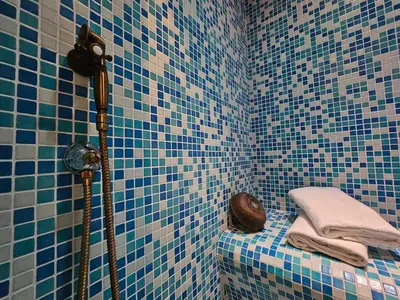 a blue tiled bathroom with a shower and towels at Private SPA Apartment in Rome in Rome