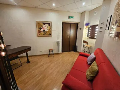 a living room with a red couch and a piano at Private SPA Apartment in Rome in Rome