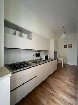 a kitchen with white cabinets and a stove top oven at Zaffiro Esquilino charming apartment in Rome