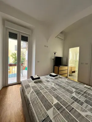 a bedroom with a large bed and a sliding glass door at Zaffiro Esquilino charming apartment in Rome