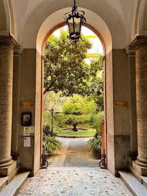 an archway leading to a garden with a tree at Zaffiro Esquilino charming apartment in Rome