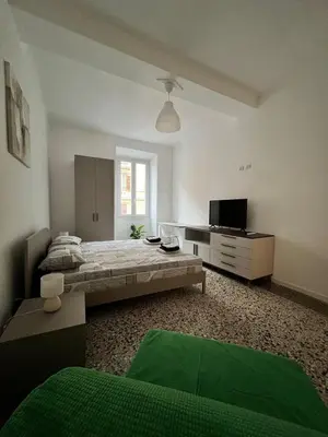 a large white room with a bed and a television at Zaffiro Esquilino charming apartment in Rome