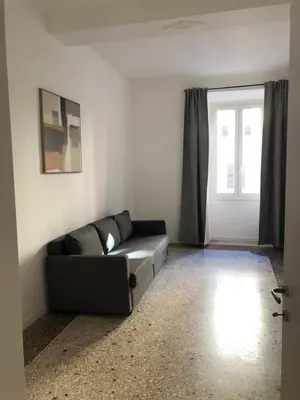 a living room with a black couch and a window at Zaffiro Esquilino charming apartment in Rome