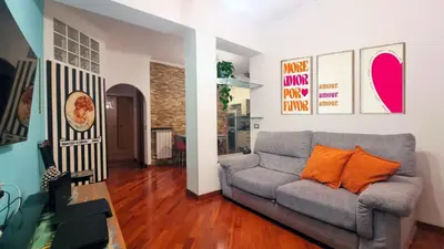 a living room with a gray couch and orange pillows at Poetry House in Rome