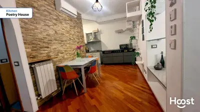 a kitchen with a table and chairs and a brick wall at Poetry House in Rome