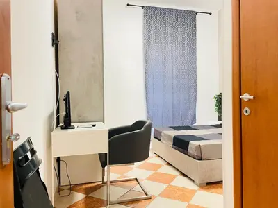 a bedroom with a bed and a desk and a chair at Residenza Abat-Jour de Rome in Rome