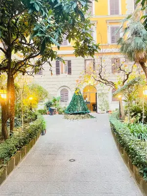 a walkway in front of a building with a christmas tree at Residenza Abat-Jour de Rome in Rome