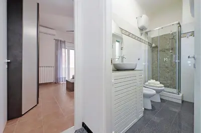 a white bathroom with a sink and a toilet at Metro Battistini- D'Alessandro Holiday Home in Rome