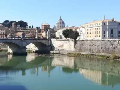 a bridge over a river with buildings in the background at Metro Battistini- D'Alessandro Holiday Home in Rome