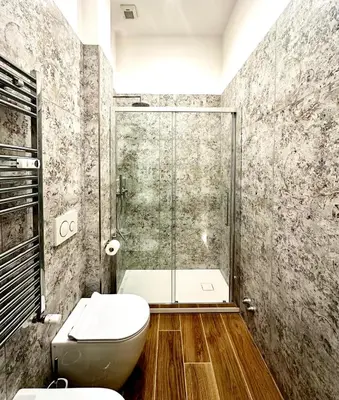 a bathroom with a toilet and a glass shower at The Temple Apartment in Rome