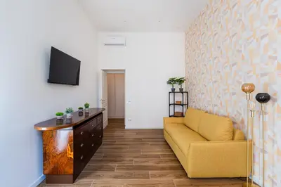 a living room with a yellow couch and a tv at The Temple Apartment in Rome
