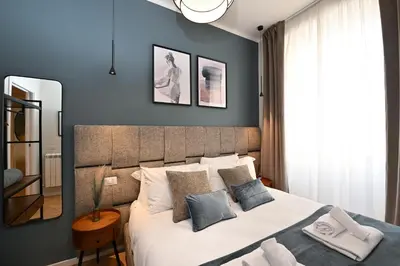 a bedroom with a large bed with blue walls at Appia Luxury Apartment in Rome