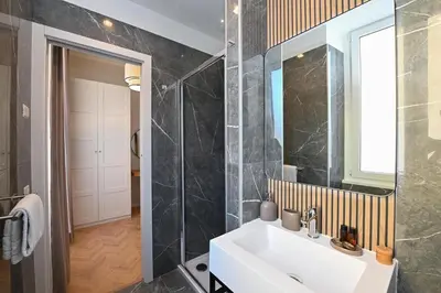 a bathroom with a white sink and a mirror at Appia Luxury Apartment in Rome