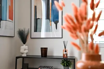 a black table with flowers and pictures on the wall at Appia Luxury Apartment in Rome