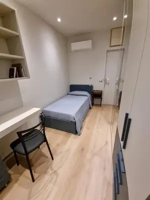 a bedroom with a bed and a desk and a chair at Domus de Core in Rome