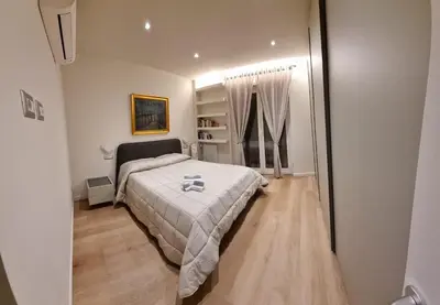 a bedroom with a bed with a white comforter at Domus de Core in Rome