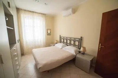 a bedroom with a bed with white sheets and a window at casa di Nadia in Rome