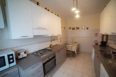a kitchen with white cabinets and a stove top oven at casa di Nadia in Rome