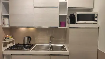 a kitchen with a sink and a microwave at Appartamento in Via dei 3 Pupazzi 12 in Rome