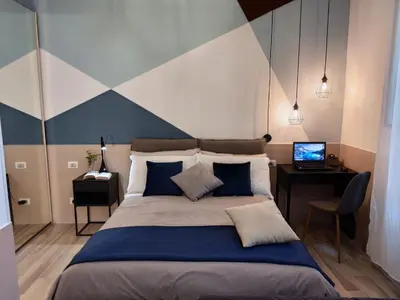 a bedroom with a bed and a desk with a laptop at Appartamento in Via dei 3 Pupazzi 12 in Rome